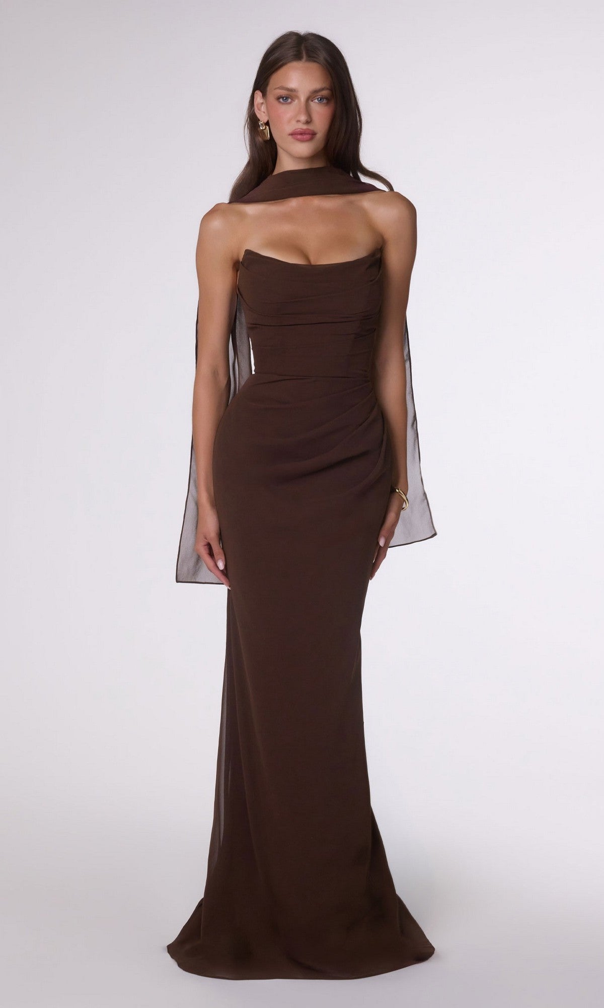 A woman wears the Espresso Lace-Up Strapless Prom Gown: Amoris T702, styled with a sheer scarf over her shoulders, standing against a plain white background.